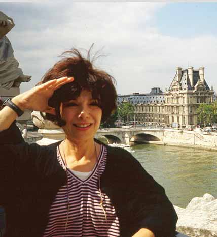 A woman saluting in front of the louvre museum. A woman saluting in front of the louvre museum.
