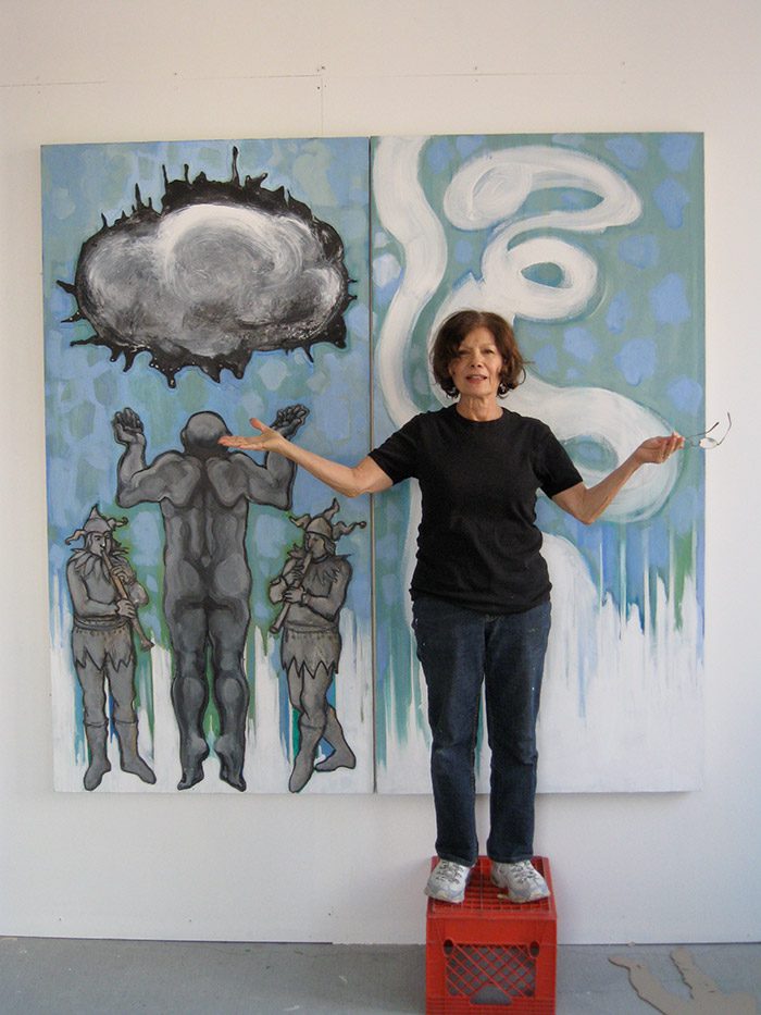 A woman standing in front of two paintings. A woman standing in front of two paintings.