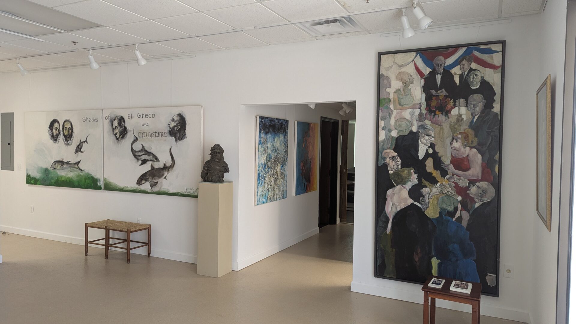 An art gallery room with various paintings and sculptures displayed.